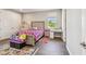 A cozy bedroom with a floral bedspread, wooden floors, a window view, and a comfortable rug at 4007 W Gray St, Tampa, FL 33609
