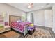 A cozy bedroom featuring hardwood floors, a colorful bedspread, and comfortable area rugs at 4007 W Gray St, Tampa, FL 33609