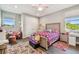 A cozy bedroom with hardwood floors, two windows for natural light, and a plush area rug at 4007 W Gray St, Tampa, FL 33609