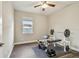 This exercise room features a weight bench, ceiling fan, window, and wood flooring at 4007 W Gray St, Tampa, FL 33609