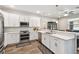 Modern kitchen featuring white cabinets, stainless steel appliances, and wood-look flooring at 4007 W Gray St, Tampa, FL 33609