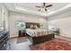 The main bedroom features a tray ceiling, ceiling fan, bed, and wood floors at 4007 W Gray St, Tampa, FL 33609
