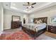 This main bedroom features a tray ceiling, wood floor, large bed, and dresser at 4007 W Gray St, Tampa, FL 33609