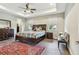 This main bedroom features a wood floor, ceiling fan, large bed, and many windows at 4007 W Gray St, Tampa, FL 33609