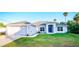 Beautiful single Gathering home with a well-manicured lawn, palm trees, and a blue front door at 4444 Boyer Ter, North Port, FL 34288