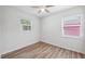 Neutral bedroom features hardwood style floors, neutral paint, and two windows for natural light at 4701 14Th S Ave, St Petersburg, FL 33711