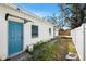 Exterior view with a side entrance door, and a small wooden deck surrounded by a white privacy fence at 4701 14Th S Ave, St Petersburg, FL 33711