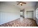 Cozy living room featuring unique tiled floors, wood walls, bright natural light, and a ceiling fan at 503 W Lee St, Plant City, FL 33563