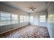 Cozy living room featuring unique tiled floors, wood walls, bright natural light, and a ceiling fan at 503 W Lee St, Plant City, FL 33563