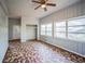 Cozy living room featuring unique tiled floors, wood walls, bright natural light, and a ceiling fan at 503 W Lee St, Plant City, FL 33563