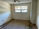 This bedroom is worn and shows deferred maintenance and a window view at 5750 80Th N St # B203, St Petersburg, FL 33709