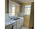 Outdated kitchen with laminate countertops, cabinetry, stainless steel sink, and a window view at 5750 80Th N St # B203, St Petersburg, FL 33709