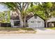 Charming home featuring a white brick exterior, chimney and a two-car garage nestled beneath a mature tree at 7227 Otter Creek Dr, New Port Richey, FL 34655