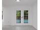 Bright living room featuring double doors offering a glimpse of the pool, fresh paint and luxury vinyl flooring at 7227 Otter Creek Dr, New Port Richey, FL 34655