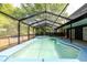 Backyard showcasing a screened-in pool with a spa and ample outdoor living space at 7227 Otter Creek Dr, New Port Richey, FL 34655