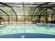 A screened-in swimming pool with an attached spa and lush greenery surround at 7227 Otter Creek Dr, New Port Richey, FL 34655