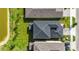 Aerial view showcases the roof, landscaping, and proximity to a pond in a residential neighborhood at 7334 Ashcroft Dr, Wesley Chapel, FL 33545