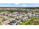 Aerial view of a residential area with a lake, showcasing homes and a green landscape at 7334 Ashcroft Dr, Wesley Chapel, FL 33545