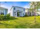 Well-maintained backyard with lush green grass, a covered patio, and a view of the two-story home at 7334 Ashcroft Dr, Wesley Chapel, FL 33545