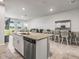 Open concept kitchen features an island with granite countertop, stainless steel dishwasher, and tile flooring at 7334 Ashcroft Dr, Wesley Chapel, FL 33545