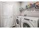 Clean laundry room with white washer and dryer and storage shelves above at 7334 Ashcroft Dr, Wesley Chapel, FL 33545