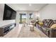 Cozy living room with large windows, a sliding glass door, and a comfortable leather reclining couch at 7334 Ashcroft Dr, Wesley Chapel, FL 33545