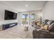 Bright living room with tile floors, a large TV, and a comfortable reclining sofa near the sliding doors at 7334 Ashcroft Dr, Wesley Chapel, FL 33545