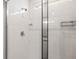 Clean and modern tiled shower with glass door, chrome fixtures, and built-in shelving at 7334 Ashcroft Dr, Wesley Chapel, FL 33545