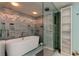 Beautiful bathtub and glass shower enclosed in tiled bathroom with mosaic details at 80 Rogers St # 2A, Clearwater, FL 33756