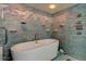 Featuring a standalone tub with decorative mosaic tile and modern shower fixture at 80 Rogers St # 2A, Clearwater, FL 33756