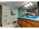Bathroom with dual vessel sinks, wooden cabinetry, and large decorative mirror at 80 Rogers St # 2A, Clearwater, FL 33756