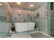 Featuring a standalone tub with decorative mosaic tile and modern shower fixture at 80 Rogers St # 2A, Clearwater, FL 33756