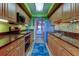 Galley kitchen with mosaic backsplash, warm wood cabinetry, and modern stainless appliances at 80 Rogers St # 2A, Clearwater, FL 33756