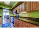 Bright kitchen with wood cabinetry, granite countertops, and stainless steel appliances leading to balcony at 80 Rogers St # 2A, Clearwater, FL 33756