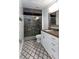 Modern bathroom features patterned tile floors, glass shower, and sink with white cabinets at 9980 Sago Point Dr, Seminole, FL 33777