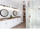 Bright bathroom featuring double sinks, decorative mirrors, shower and updated fixtures at 9980 Sago Point Dr, Seminole, FL 33777