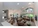 Open-concept living space with soaring ceilings, expansive windows, and seamless flow to the dining area at 9980 Sago Point Dr, Seminole, FL 33777