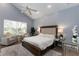 Cozy main bedroom features a large window, ceiling fan, sitting area, and neutral decor at 9980 Sago Point Dr, Seminole, FL 33777