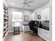 Bright office space with built-in bookshelves, granite countertops, white cabinets and a ceiling fan at 9980 Sago Point Dr, Seminole, FL 33777