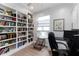 Bright office space with built-in bookshelves, granite countertops, white cabinets and a ceiling fan at 9980 Sago Point Dr, Seminole, FL 33777