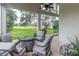 Screened patio with comfortable seating around a stone fire pit overlooking a lush green lawn at 9980 Sago Point Dr, Seminole, FL 33777