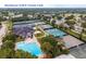 Aerial view of the Bardmoor Golf & Tennis Club with tennis courts and swimming pool surrounded by lush trees at 1002 Cordova Grn, Seminole, FL 33777