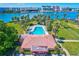 Aerial view of the pool and pool house surrounded by palm trees and lush greenery, offering a private and refreshing escape at 10190 Imperial Point W Dr # 8, Largo, FL 33774