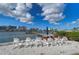 Common area with white Adirondack chairs, picnic table, and BBQ grills overlooking the bay, perfect for community gatherings and relaxation at 10190 Imperial Point W Dr # 8, Largo, FL 33774