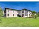 A lush green lawn and stucco exterior features a covered balcony and well maintained landscape at 10190 Imperial Point W Dr # 8, Largo, FL 33774