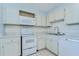 This kitchen features white appliances and ample counter space, with white-washed cabinetry at 10190 Imperial Point W Dr # 8, Largo, FL 33774