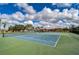 Well-maintained tennis courts surrounded by lush landscaping and a vibrant blue sky dotted with clouds at 10190 Imperial Point W Dr # 8, Largo, FL 33774