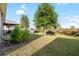 Large backyard with green grass, a border of lush plants, and covered outdoor seating at 10196 Cross Timber Ter, Land O Lakes, FL 34638