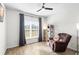 Bedroom featuring a ceiling fan, wood-look tile floors, large windows, and space for a chair and cat tree at 10196 Cross Timber Ter, Land O Lakes, FL 34638