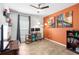 Bright bedroom with hardwood floors and an orange accent wall, plus decorative shelves and artwork at 10196 Cross Timber Ter, Land O Lakes, FL 34638